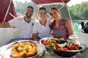 Moderatorin Tamina Kallert (r) mit Antonis Marakas und Alexandra Maraka (M). Sie probieren auf einer Tour mit dem Segelboot typische griechische Speisen.