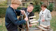 Andr&eacute; (m) und Astrid haben Oli P. (l) die Einzelteile einer alten Holz-Waschmaschine mitgebracht.