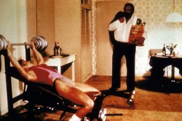 Steve (Bud Spencer, r.) und seine Kollegin, die FBI-Agentin Irene (Jackie Castellano, l.), halten sich auf unterschiedliche Weise fit: Steve isst w&auml;hrend Irene trainiert ...