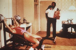 Steve (Bud Spencer, r.) und seine Kollegin, die FBI-Agentin Irene (Jackie Castellano, l.), halten sich auf unterschiedliche Weise fit: Steve isst w&auml;hrend Irene trainiert ...
