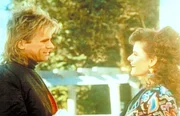 Lulu (Tamsin Kelsey, r.) bietet MacGyver (Richard Dean Anderson, l.) an, ihn nach Hause zu bringen, nachdem sie sein Fahrrad demoliert hat. Lulu (Tamsin Kelsey, r.) bietet MacGyver (Richard Dean Anderson, l.) an, ihn nach Hause zu bringen, nachdem sie sein Fahrrad demoliert hat.