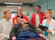 Fabian Althaus (Daniel Krauss, liegend) wird von den Not&auml;rzten (Komparsen) in die Sachsenklinik eingeliefert. Dr. Kathrin Globisch (Andrea Kathrin Loewig, re.) und Oberschwester Ingrid (Jutta Kammann, li.) nehmen den Patienten in Empfang.
