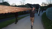 Eine riesige Fackel wird in G&ouml;sseling zum Osterfeuer getragen.