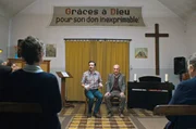 Die Gemeinde von Pfarrer Bruno (Jean-Fran&ccedil;ois Gallotte, re.) ist fest davon &uuml;berzeugt, dass hinter Toms (Lucas Meister, li.) Autounfall eine politische Verschw&ouml;rung steckt.