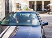 Orkan (Flavius Budean) hat sich ein Auto gekauft und f&auml;hrt mit Jule (Maja Hieke) auf dem Internatshof vor.