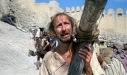 Brian (Graham Chapman) auf dem Weg zu seiner Kreuzigung..