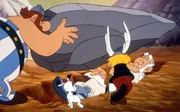 Ausversehen trifft Obelix (li.) nicht die R&ouml;mer sondern Miraculix (re.). Asterix (Mi.) ahnt, dass dies gro&szlig;e Folgen f&uuml;r die Gallier haben wird.