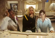 Ford (MOS DEF, left), Zaphod (SAM ROCKWELL, center), and Trillian (ZOOEY DESCHANEL, right),  try to figure something out on the bridge of the Heart of Gold, while Marvin the Paranoid Android (rear) is too depressed to think about it in a scene from the hilarious comedy, "The Hitchhiker's Guide to the Galaxy," directed by Garth Jennings and produced by Nick Goldsmith.