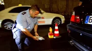 Der Beamte kontolliert ein Auto.