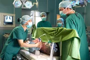 Adrian Walter (Marko Dyrlich, liegend) hat nach seinem Fahrradunfall schwerste Verletzungen. W&auml;hrend der OP kommt es zu Komplikationen. Dr. Kathrin Globisch (Andrea Kathrin Loewig, li.) bittet Dr. Philipp Brentano (Thomas Koch, re.) zu unterbrechen. Als es sogar zum Herzstillstand kommt und Kathrin den Defibrillator ansetzen will, traut sie ihren Augen nicht: Adrian ist wach! Mitte: zwei Komparsen