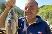 Fischer Ded Nika mit Bachforellen aus einem Gebirgsbach.