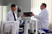 Dr. Kaminski (Udo Schenk, links) bittet Hans-Peter Brenner (Michael Trischan) die Voruntersuchung einer Patientin zu &uuml;bernehmen. Die erste Freude &uuml;ber Kaminskis entgegengebrachtes Vertrauen, l&auml;sst bei dem angehenden Arzt Hans-Peter allerdings schnell wieder nach, als Kaminski hinterherschie&szlig;t, dass man bei dieser Untersuchung eh nichts falsch machen kann.