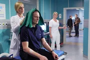 W&auml;hrend sein Kollege Ralf mit einer lebensgef&auml;hrlichen Schussverletzung operiert wird, hat Jan Fischer (Thorsten Nindel, sitzend) nur eine leichte Kopfverletzung. Dr. Lea Peters (Anja Nejarri, li.) &uuml;bernimmt die Erstversorgung, will aber zur Sicherheit noch ein CT durchf&uuml;hren. Eine Schwester (Komparsin, mi.) k&uuml;ndigt zwei Polizisten (Komparsen, re.) an, die in dem &Uuml;berfall ermitteln.