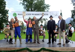 Pfarrer Ludwig (Gerhard Wittmann) und Bankberater Kurt (Robert Giggenbach, re.) zeichnen die lokalen Bauern aus, darunter auch das Team Elli (Jutta Speidel, re.) und Raymond (Christofer von Beau).