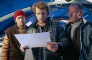 Zusammen mit Brian Maki (Robert Mammone, l.) und Frank Williams (David Hayman, r.) versucht Peter Garrett (Chris O&rsquo;Donnell, M.) herauszufinden, wie sie seine Schwester und die anderen retten k&ouml;nnen.