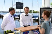 Ivo (Aleksandar Jovanovic, M.) bekommt &Auml;rger von seinem Chef (Kida Khodr Ramadan, l.), w&auml;hrend Isabel (Katharina Sch&uuml;ttler, r.) geduldig auf ihre Bestellung wartet.