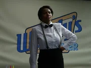 Saudi in her uniform with her hand on her hip at the diner.