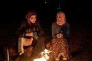 Zwischen Amina (Anjana Vasan, r.) und Ayesha (Juliette Motamed, l.) kommt es am Lagerfeuer zur ehrlichen Aussprache ein erster Schritt in Richtung Freundschaft?
