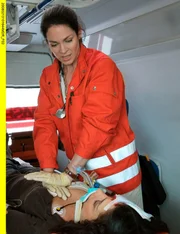 Dr. Elena Eichhorn (Cheryl Shepard, oben) versucht Valerie Stein (Jany Tempel, unten) verzweifelt im Notarztwagen zu reanimieren. Doch wie damals bei Alina Heilmann, kann sie sie nicht mehr retten. Valerie stirbt.