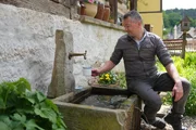 Felix Zschoge genie&szlig;t das frische Quellwasser am Umgebindehaus in der S&auml;chsischen Schweiz.