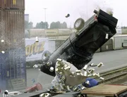 Der Gangster kracht mit seinem Pickup in ein Hindernis, hebt ab und landet im Hafenbecken...