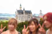 Touristen posieren auf der Marienbr&uuml;cke vor der Neuschwanstein-Kulisse.