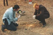 Tim Speedle (Rory Cochrane, l.) sucht das Gebiet um den Baum ab und findet einen kleinen, blutverschmierten Stofffetzen. Horatio (David Caruso) stellt erstaunt fest, wie viele Fu&szlig;abdr&uuml;cke um den Baum herum sind, obwohl der Fundort der Leiche recht einsam liegt.