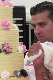 Buddy Valastro and Jessica Bacchus work on the flower cake.