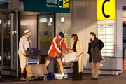 Herzberger (Dietmar Huhn, li.) und Bonrath (Gottfried Vollmer, 2.v.li.) sto&szlig;en am Flughafen mit Sabine Prinz (Julia Thurnau) und Marcus Degen (Alexander Lutz) zusammen. Wer hat jetzt welchen Koffer?