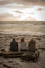 Hauke Jakobs (Hinnerk Sch&ouml;nemann), Jule Christiansen (Marleen Lohse) und ( Henny Reents) lassen den Tag, nach dem gel&ouml;sten Fall, am Strand ausklingen.