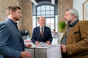W&auml;hrend der Notar Randolf Hanewinkel (Michael Walde-Berger, 2.v.l.) von den Kommissaren Hansen (Igor Jeftić, l.) und Stadler (Dieter Fischer, r.) befragt wird, verfolgt Notariatsmitarbeiterin Elda Wieland (Ina Meling, 2.v.r.) im Hintergrund das Geschehen.