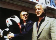 Nelson Brenner (Patrick McGoohan, li.) trifft sich mit Geronimo (Leslie Nielsen) auf einem Rummelplatz.