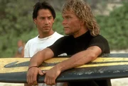 Schnell freundet sich FBI-Agent Johnny Utah (Keanu Reeves, l.) mit der Clique um den Surfer Bodhi (Patrick Swayze, r.) an. Doch schon bald muss er sich zwischen seinem Job und der Loyalit&auml;t zu seinem neuen Freund entscheiden ...
