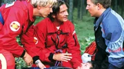 Peter (Serge Falck, l.) und Dr. L&uuml;dwitz (Rainer Grenkowitz) bem&uuml;hen sich, um die lebensgef&auml;hrlich verletzte Kathrin (Julia Cencig) am Leben zu erhalten. Doch leider hat ihr Mann Bernd (Lars Pape) den Motoradhelm abgezogen, bevor das Rettungsteam vor Ort war...