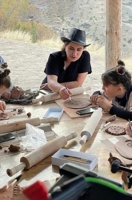 Arus (Mi.) stellt im Workshop mit Kindern und Jugendlichen Figuren aus Ton her.