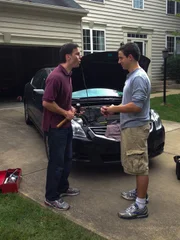 The DeWild brothers working on a car together in the driveway.