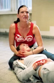 Ines (Freya Trampert, lieg.) liegt sterbend in Walters (Katy Karrenbauer) Armen...