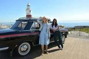 Pia (Birte Hanusrichter, l.) ist den weiten Weg von Sevilla nach Gibraltar mit dem Taxi gekommen. Nun wartet sie zusammen mit der Taxifahrerin Flora (Collien Ulmen-Fernandes, r.) auf Pias Verabredung John am Leuchtturm von Gibraltar.