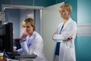 Dr. Lea Peters (Anja Nejarri, links) sucht nach der Ursache f&uuml;r den schweren Sturz ihres Patienten Rainer Heitz. Dieser leidet seit geraumer Zeit unter Schwindelattacken, die schlie&szlig;lich zu dem Unfall gef&uuml;hrt haben. Da Lea jedoch keinen Grund finden kann, bittet sie Dr. Kathrin Globisch (Andrea Kathrin Loewig) um Mithilfe.