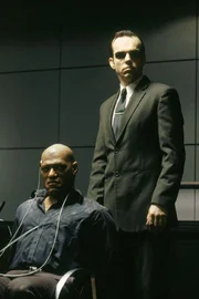 Morpheus (Laurence Fishburne, l.) ist in die F&auml;nge von Mr. Smith (Hugo Weaving) geraten. Der Agent hofft, nun endlich den Widerstand der letzten freien Menschen brechen zu k&ouml;nnen.