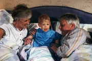 Ein seltener, aber diesmal ganz besonders gern gesehener Gast im Ehebett der Gro&szlig;eltern Hannelore (Maria Sebaldt, l.) und Eberhard (Stephan Orlac, r.) ist der wieder gesunde kleine Thomas (Jean Michel Cortes).