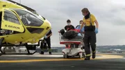 Paramedic Mikie pushing patient across helipad of Leeds General