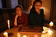 Nancy Bowen (Cheyenne Quintanar) and Lila Jimerson (Mikayla Campbell) use the Ouija board.