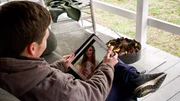 BRANDON on his porch video chatting with JULIA