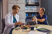 Sofia Galura (Olivia Papoli-Barawati, r.) zeigt Dr. Mikko Rantala (Luan Gummich, l.) einen Fachartikel, der Aufschluss &uuml;ber ihren aktuellen Patientenfall geben k&ouml;nnte.