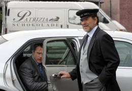 Ernst Schmitt (G&ouml;tz George, rechts) arbeitet als Chauffeur f&uuml;r den korrupten Betriebschef Gr&auml;ber (Pierre Besson), der von seinen Angestellten sarkastisch "Toten-Gr&auml;ber" genannt wird.