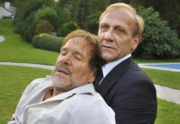 Chauffeur Hubert (Karl Kranzkowski, re.) bringt seinen Chef Ernst Schmitt (G&ouml;tz George, li.) nach einem Herzanfall ins Krankenhaus.; ARD Degeto SCHOKOLADE F&Uuml;R DEN CHEF, am Samstag (02.11.24) um 14:00 Uhr im ERSTEN. Chauffeur Hubert (Karl Kranzkowski, re.) bringt seinen Chef Ernst Schmitt (G&ouml;tz George, li.) nach einem Herzanfall ins Krankenhaus. &copy; ARD Degeto/Martin Menke, honorarfrei - Verwendung gem&auml;&szlig; der AGB im engen inhaltlichen, redaktionellen Zusammenhang mit genannter Degeto-Sendung und bei Nennung "Bild: ARD Degeto/Martin Menke" (S2). ARD Degeto/Programmplanung und Presse, Tel: 069/1509-335, degeto-presse@degeto.de