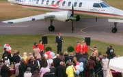 Festliche Stimmung auf dem Flugplatz Uelzen: Malte Neumann (Marcus Bluhm, M.) begr&uuml;&szlig;t die geladenen G&auml;ste und gibt den Start seiner Fluglinie "Malte-Air" bekannt.