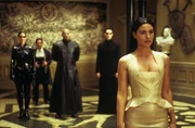 Morpheus (Laurence Fishburne, hinten, 3.v.r.), Trinity (Carrie-Anne Moss, l.) und Neo (hinten r.) treffen die Frau des Merowingers, Persephone (Monica Belluci, vorne) in einem luxuri&ouml;sen Restaurant in einer Stadt der Matrix.