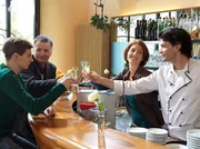 Roland Heilmann (Thomas R&uuml;hmann, 2. von links), Pia (Hendrikje Fitz, 2. von rechts) und Freddy Kerr (Luca Zamperoni, rechts) sto&szlig;en mit Jakob (Karsten K&uuml;hn) auf seine bestandene Pr&uuml;fung zum Forstwirt an. Doch als Freddy fragt, ob der Job denn spannend ist, wirkt Jakob pl&ouml;tzlich nachdenklich und zweifelnd.